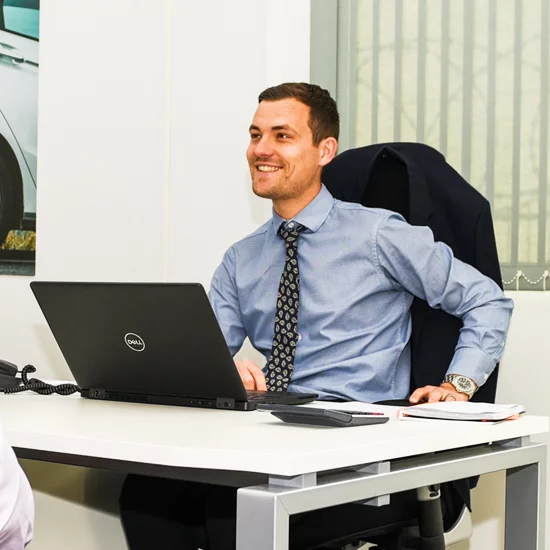 Man sat smiling at desk
